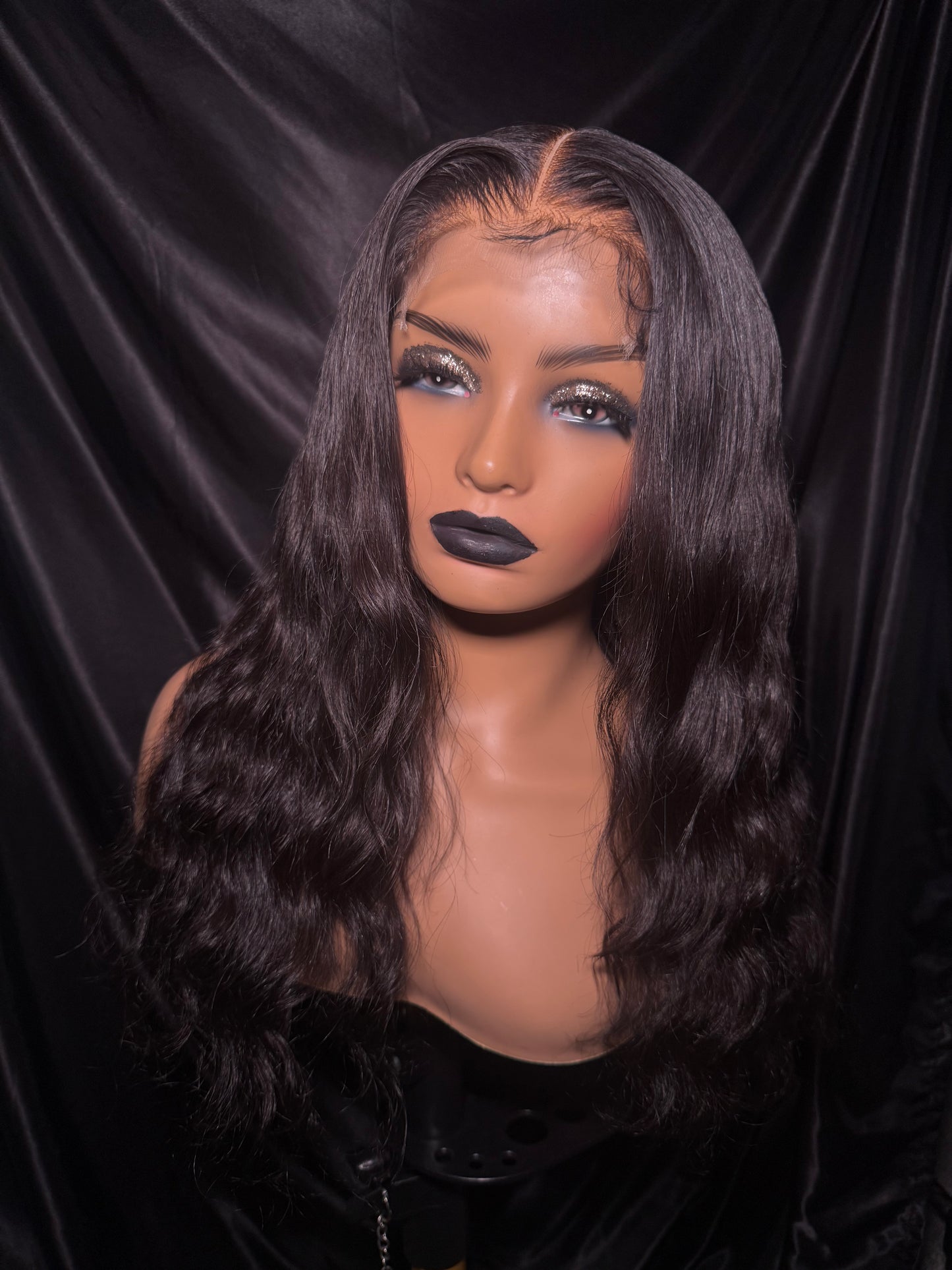 a natural wave wig against a dark background