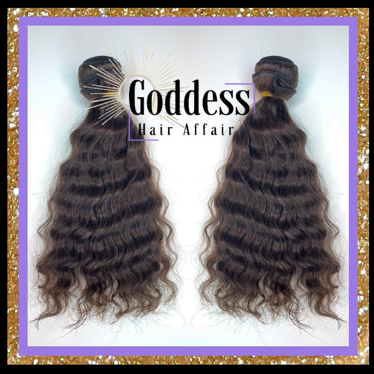 A photo of two Raw Natural Wave Bundles of hair extensions with a label that reads 'GODDESS HAIR AFFAIR'.