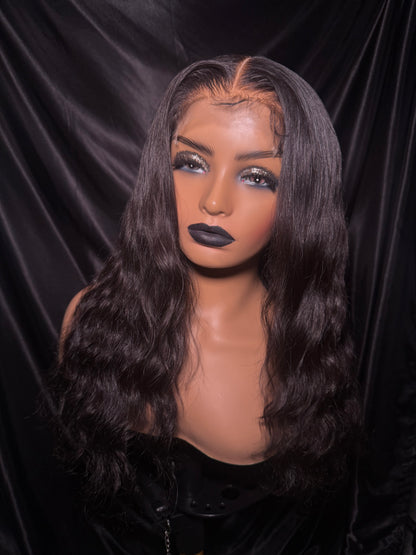 a natural wave wig against a dark background